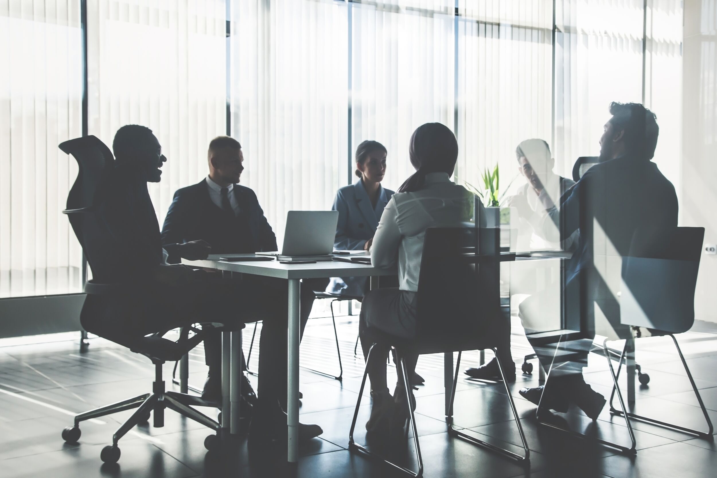 Coworkers meeting in a glass office room.